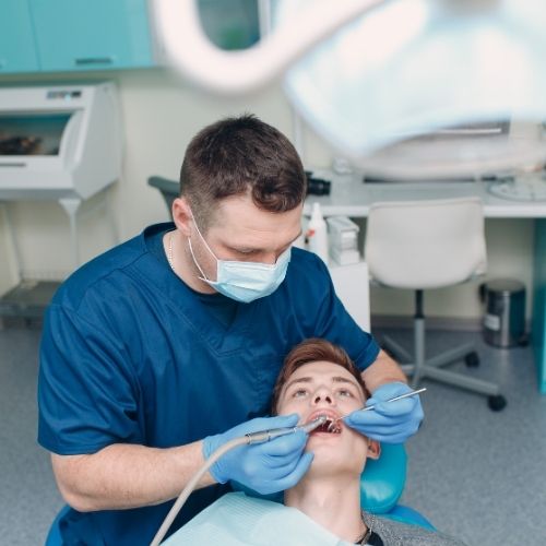 Dentist performing a routine dental examination after a root canal on a patient at Walk in the Park Family Dental in Kitchener