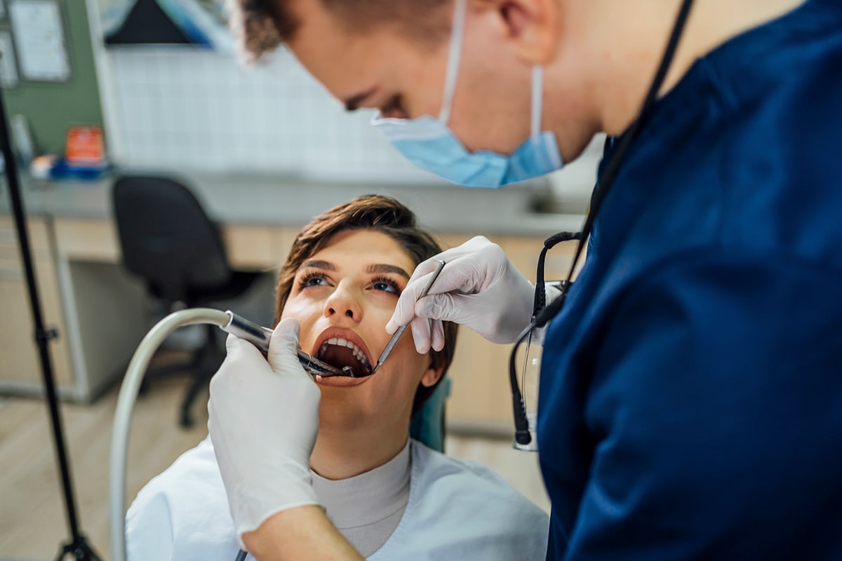 Emergency root canal treatment in dental clinic Dentist using dental tools to treat patient with open mouth during emergency root canal procedure